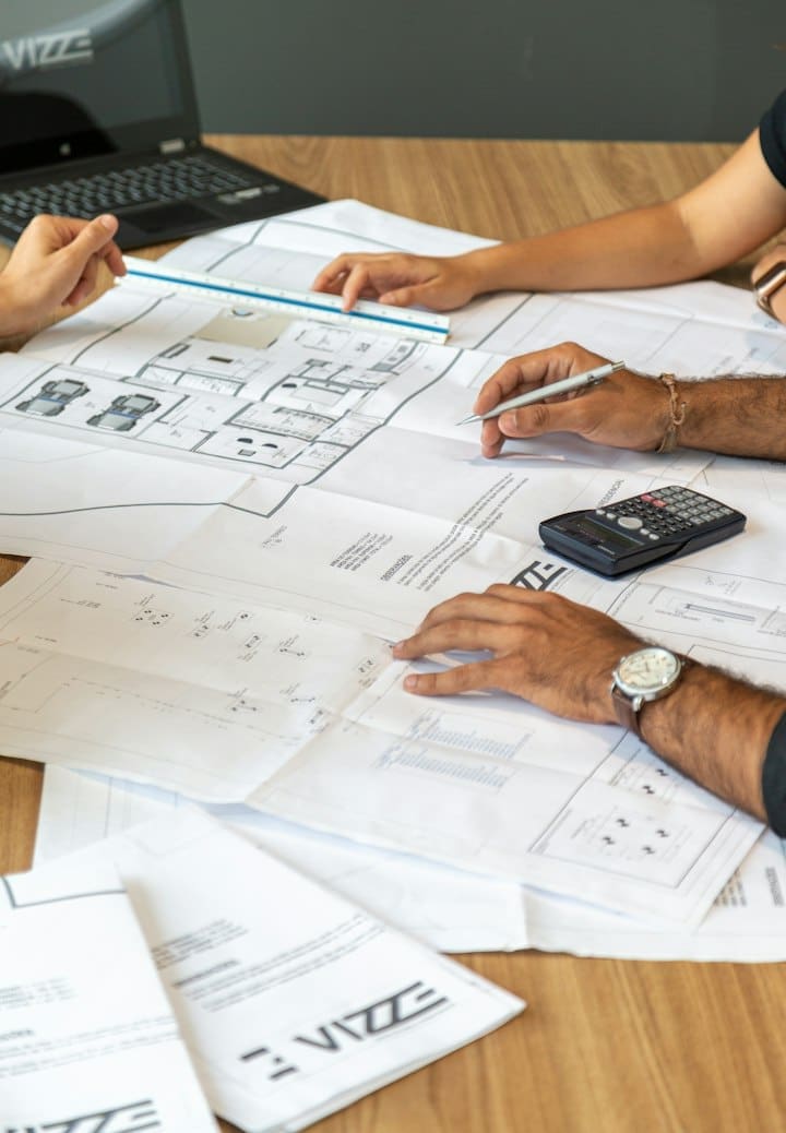 People reviewing architectural drawings at a desk