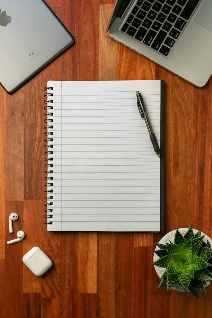 Desk arranged with a notebook and digital work tools